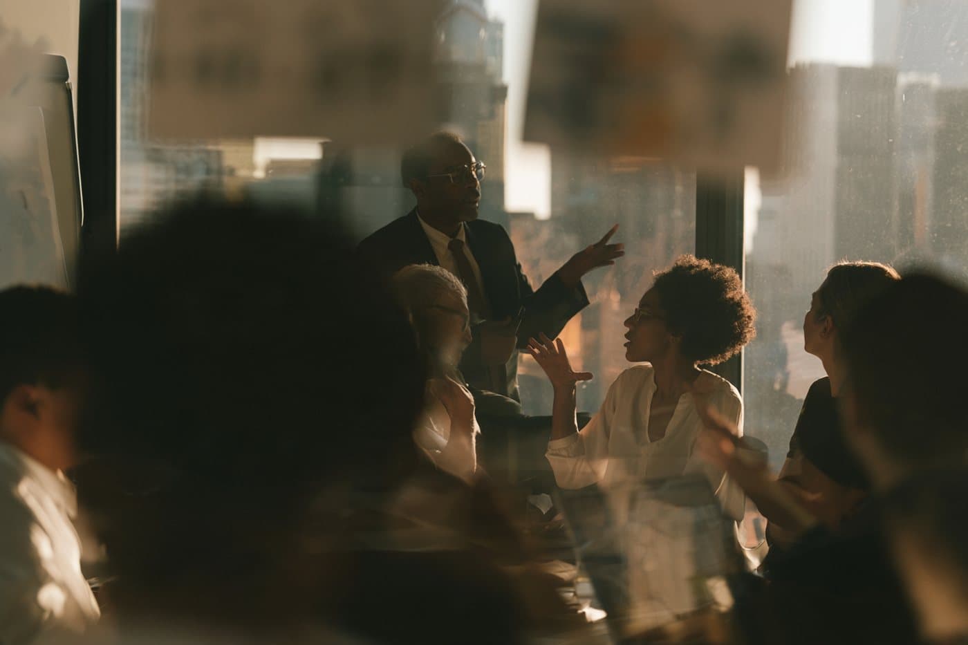 A consulting team in a working session by an office window.